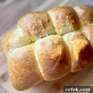 A close-up view of a loaf of sourdough brioche on a cutting board.