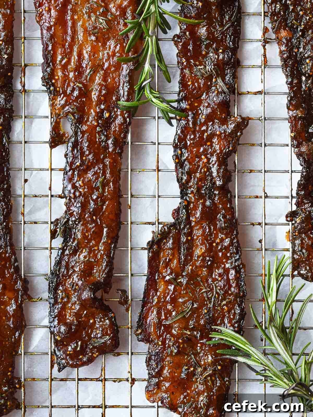 Oven-baked fig jam candied bacon with fresh rosemary.