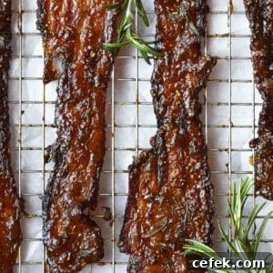 Candied bacon with rosemary on a wire rack.