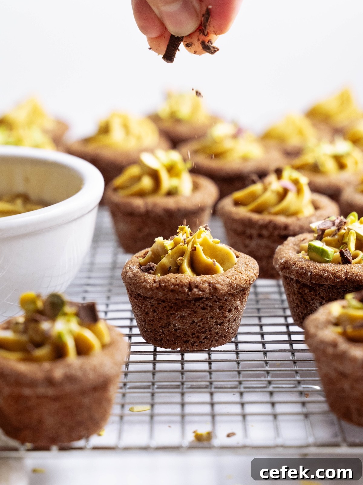 Sprinkling chopped chocolate onto cookie cups