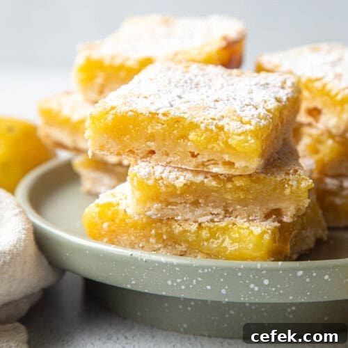 stack of three lemon bars on a small green cake stand.