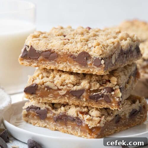 three oatmeal caramelitas stacked on a white plate.