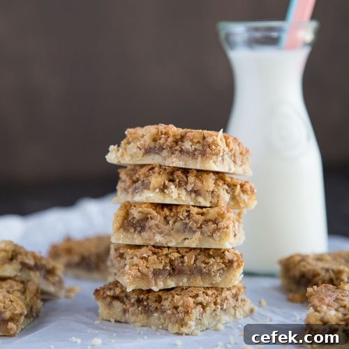 coconut bars stacked on parchment paper with a glass of milk