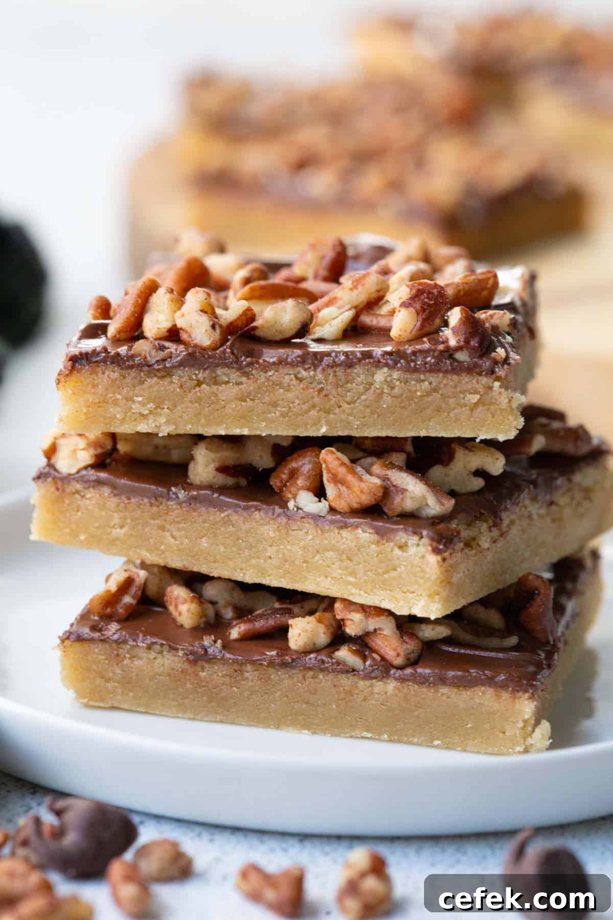 three toffee squares stacked on a white plate.