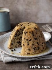 Vegan spotted dick with a slice removed.