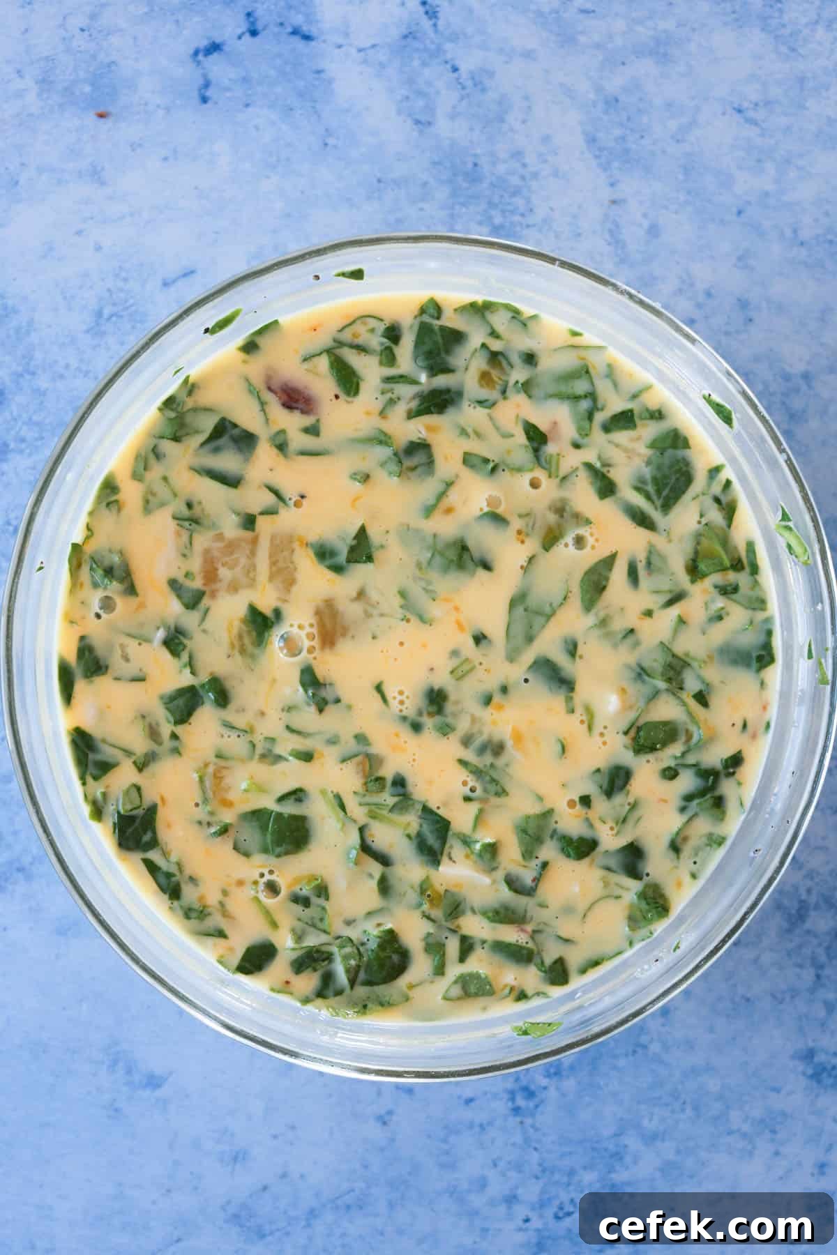 Egg bite ingredients mixed together in a glass mixing bowl.