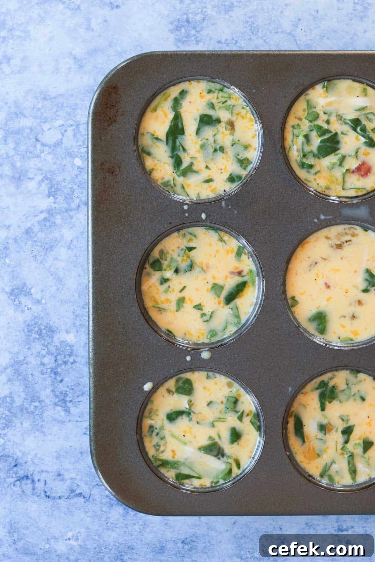 Egg bite mixture in a muffin tin.