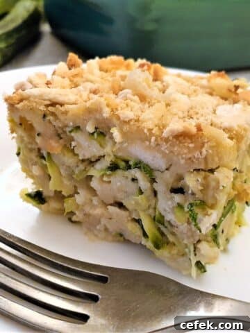A slice of cheesy zucchini bake on a plate with a fork.