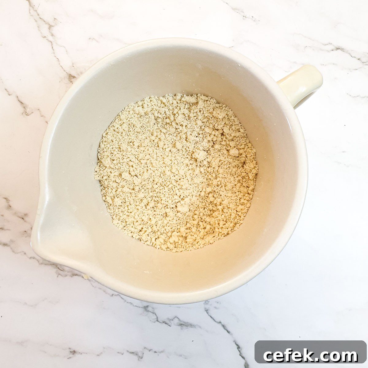 Flour and butter rubbed into breadcrumbs in a mixing bowl.
