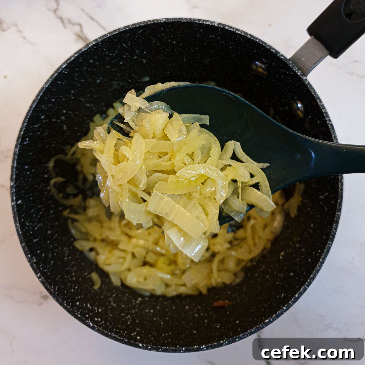 Onions caramelising in a saucepan.