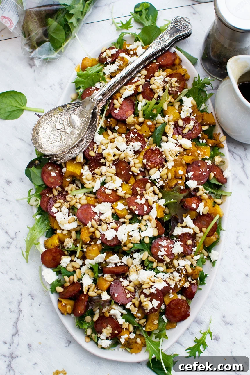 Warm roasted pumpkin, chorizo and feta salad on an oval plate and with servers in it from above