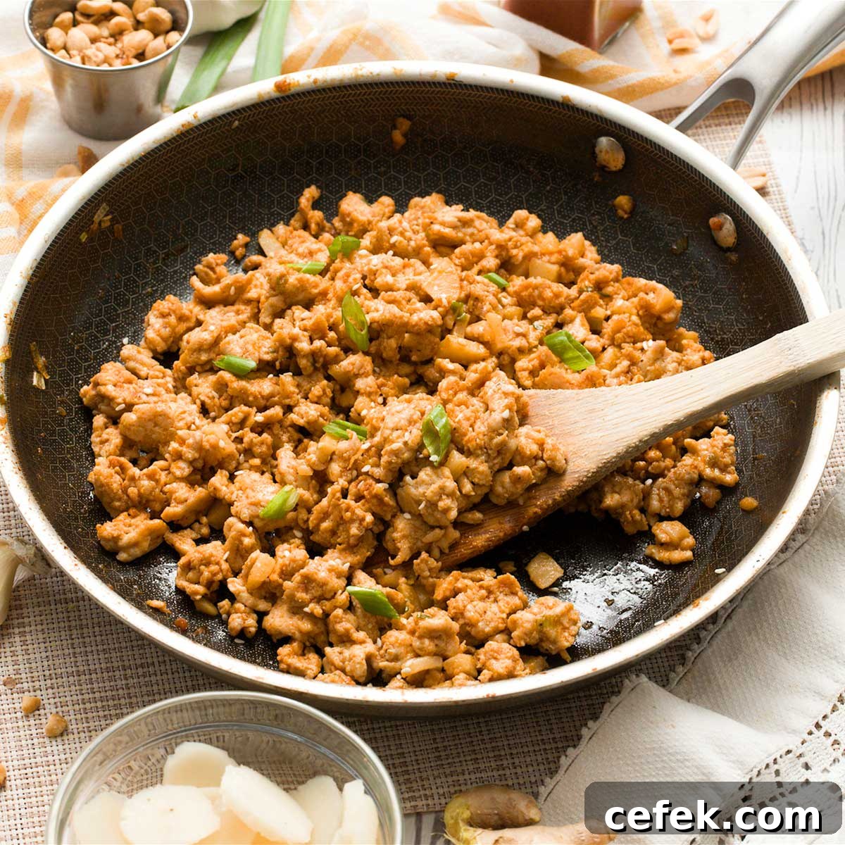 Asian ground chicken filling in a HexClad hybrid pan with a wooden spatula.