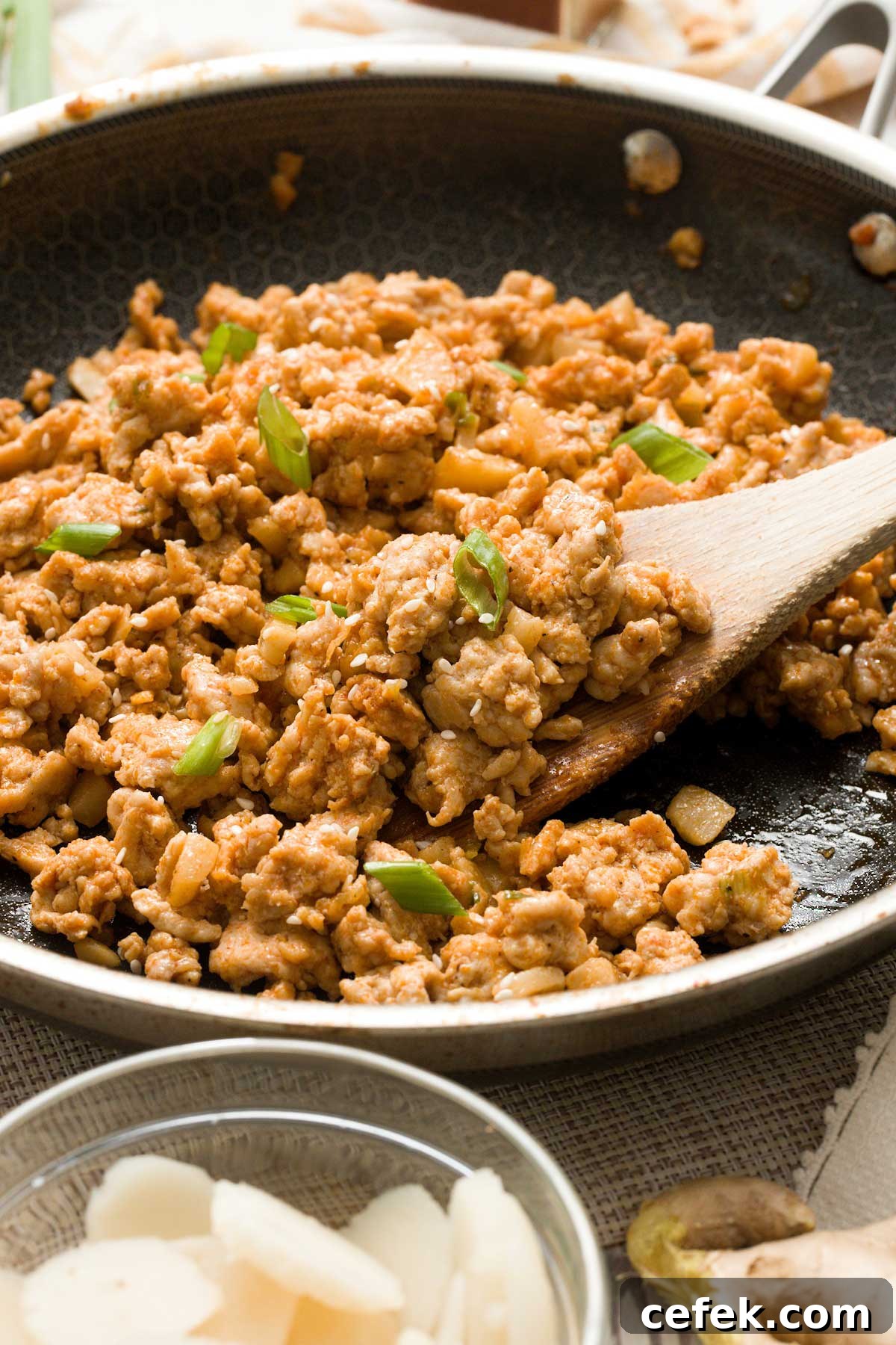 A close-up of the ground chicken filling with Green onions and sesame seeds on top