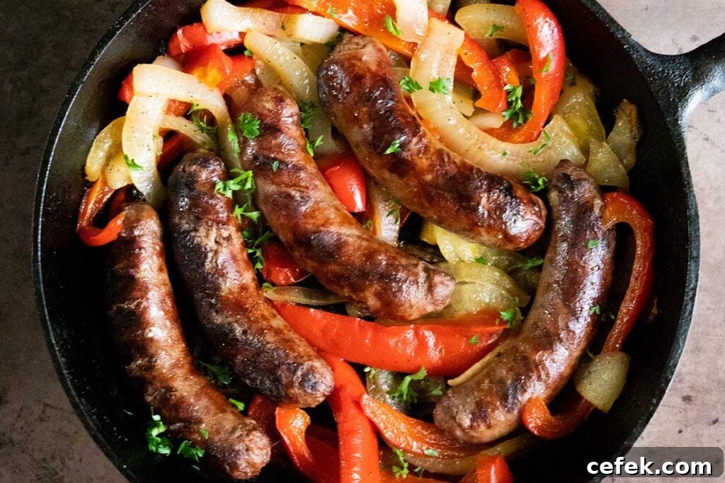 Beer brats with peppers and onions in a cast iron skillet.