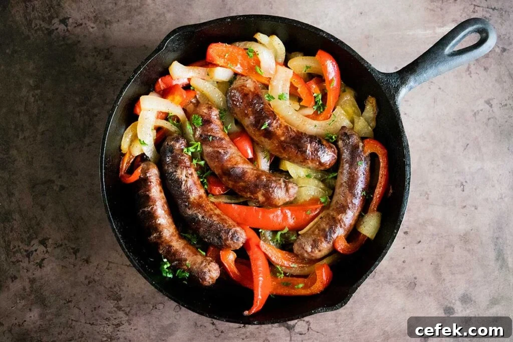 grilled beer brats with onions and peppers in a cast iron skillet