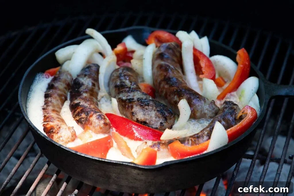Beer brats with onions and peppers on the grill