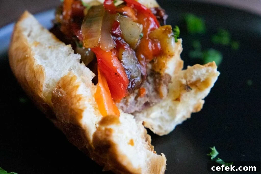 A half eaten beer brat on a black plate