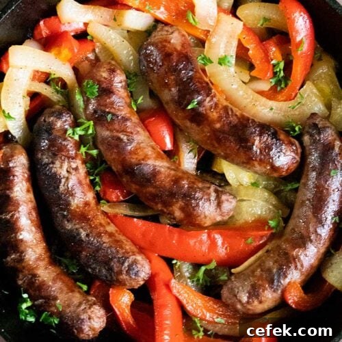 Beer brats with peppers and onions in a cast iron skillet.