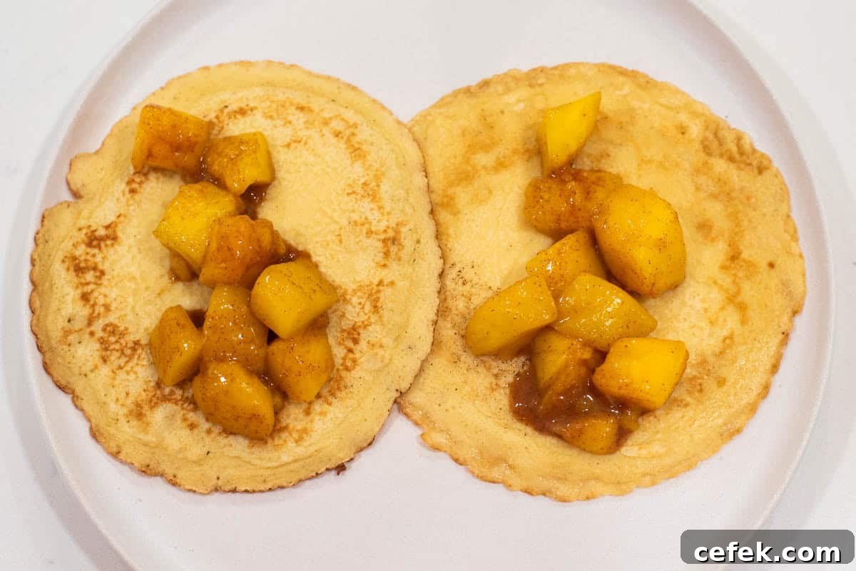 2 crepes with mango filling in the middle of each on plate.