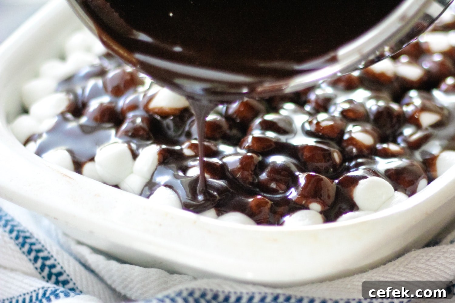 pouring chocolate frosting on mississippi mud cake
