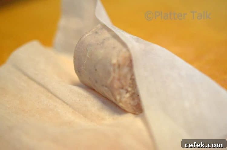 a brat bite getting rolled up in a pastry dough