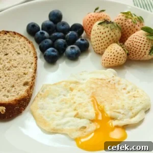 over easy egg with runny yolk, toast, and berries on the side.