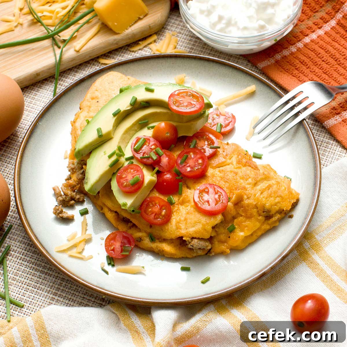 A high-protein cottage cheese omelet with tomatoes and avocado slices on top.