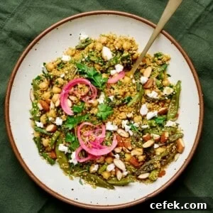 Large white plate with quinoa salad, pickled onion and vegan feta.