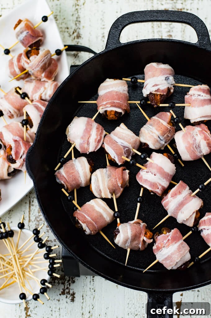 A black cast iron skillet holds bacon wrapped dates, uncooked.