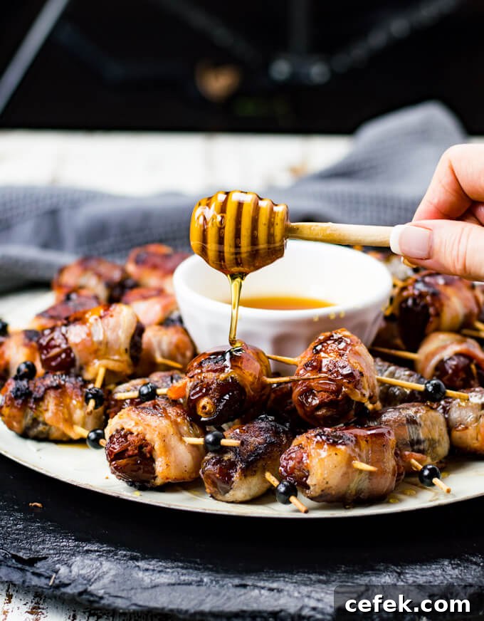 A platter of bacon wrapped dates with honey drizzling over them.