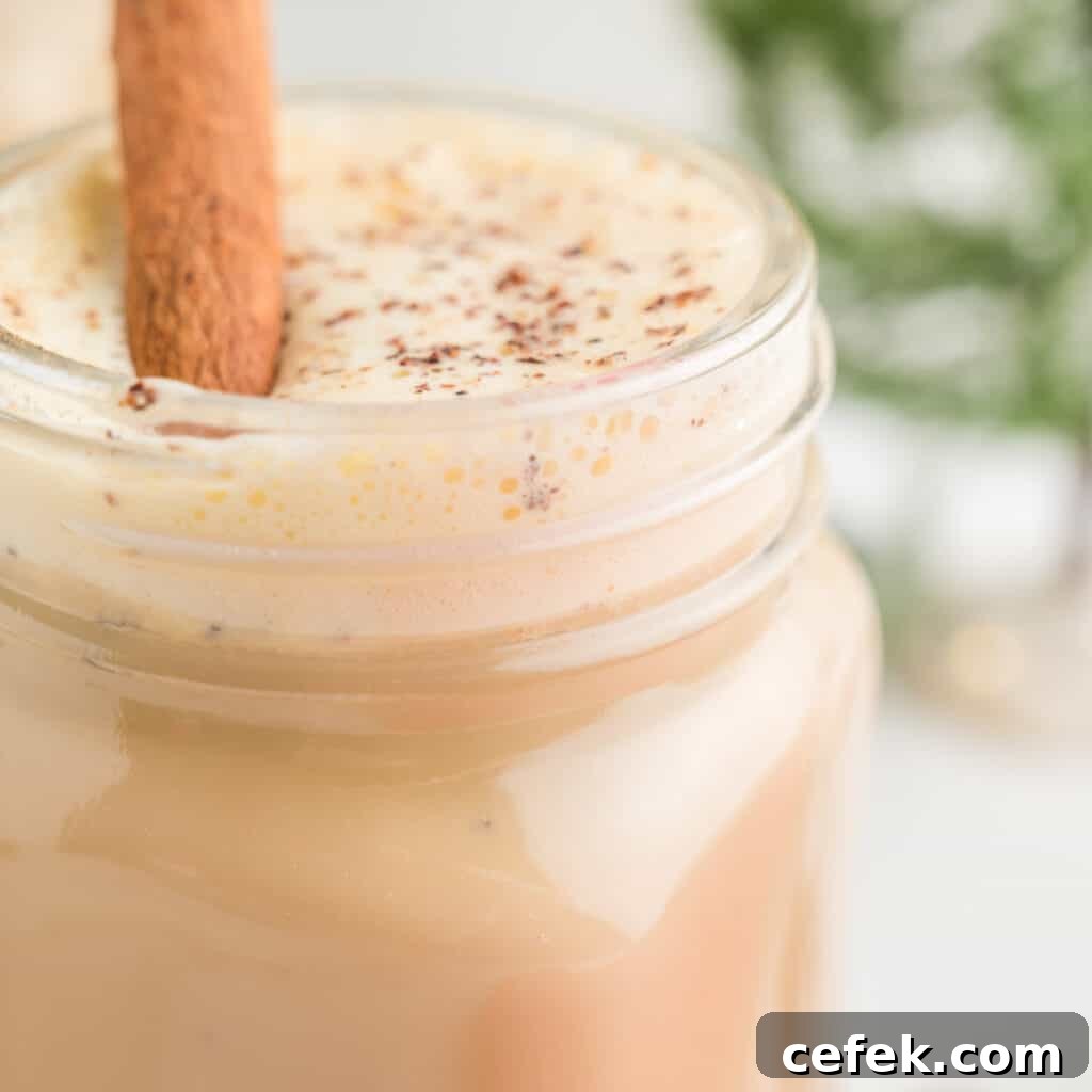 Up close photo of a eggnog latte. Cinnamon stick poking out the top.