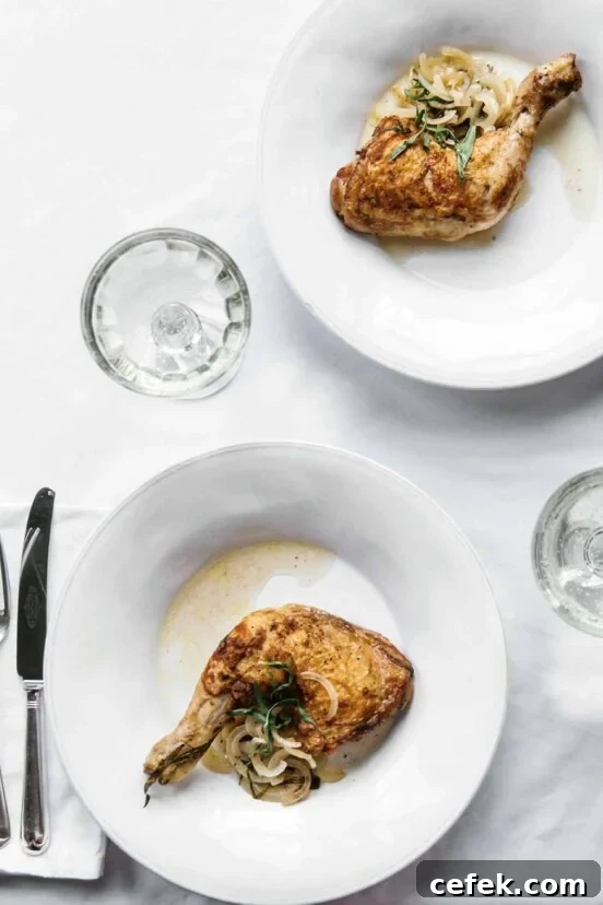 Two white plates with tarragon chicken leg and thigh on each, sliced onion and tarragon on top