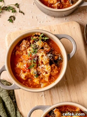 Cowl of Italian sausage kale soup filled with ditalini pasta, wilted kale, sausage, and shaved Parmesan.