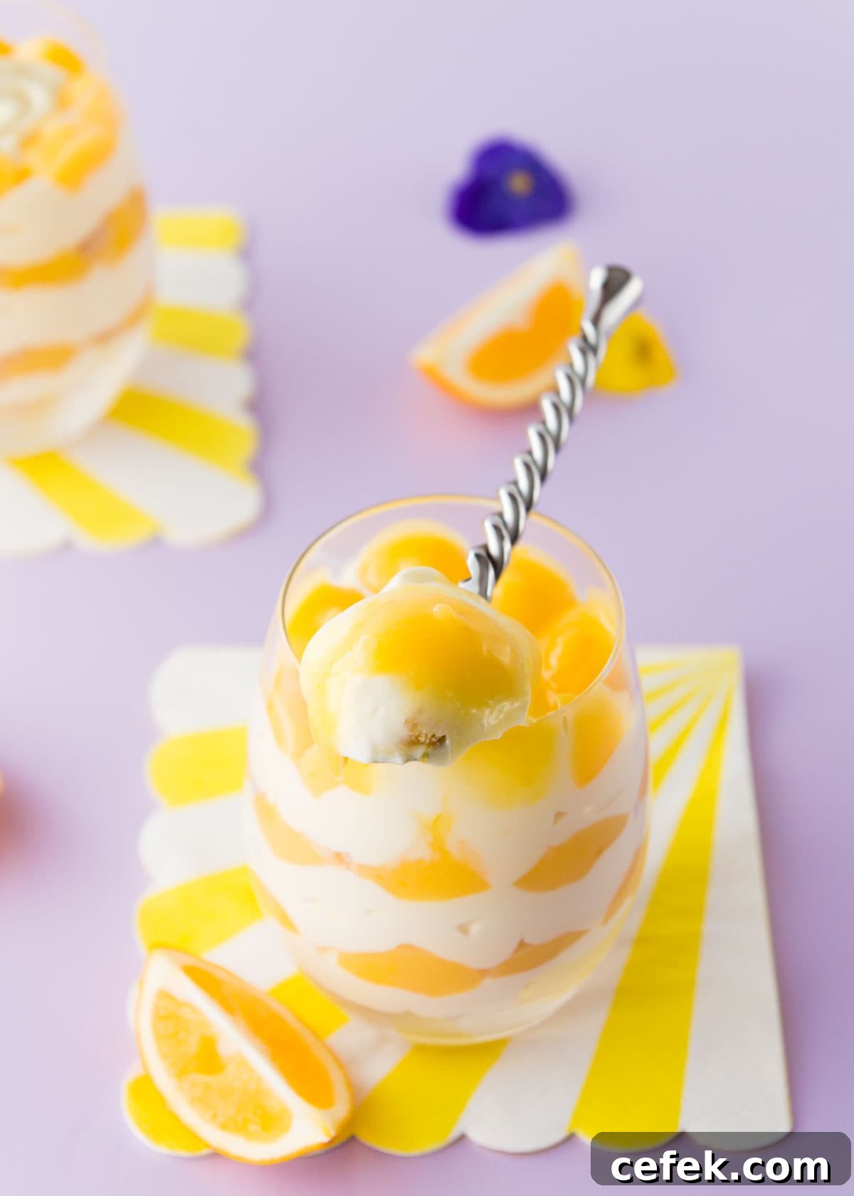 A spoonful of lemon cheesecake resting on the edge of the glass.