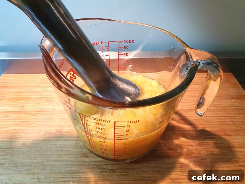 blitzing pineapple in jug with immersion blender.