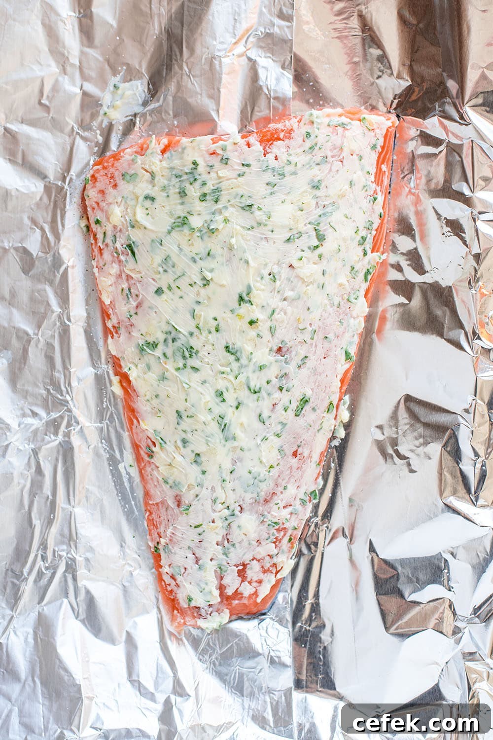 Uncooked steelhead trout covered in herb butter paste.