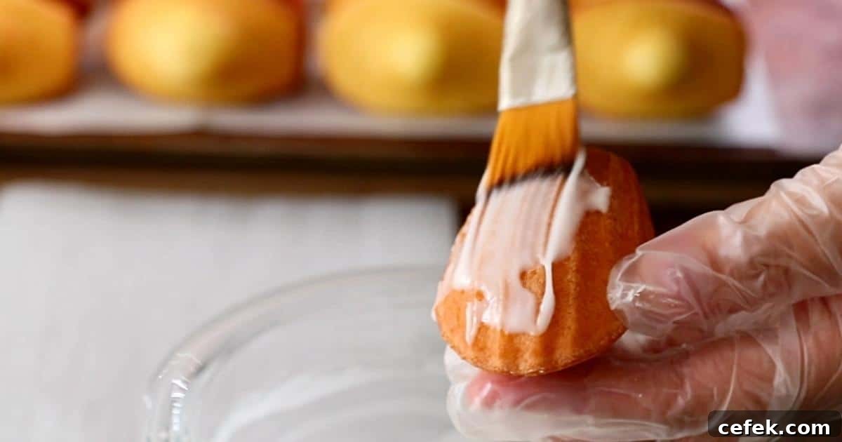 coating lemon icing on lemon madeleines