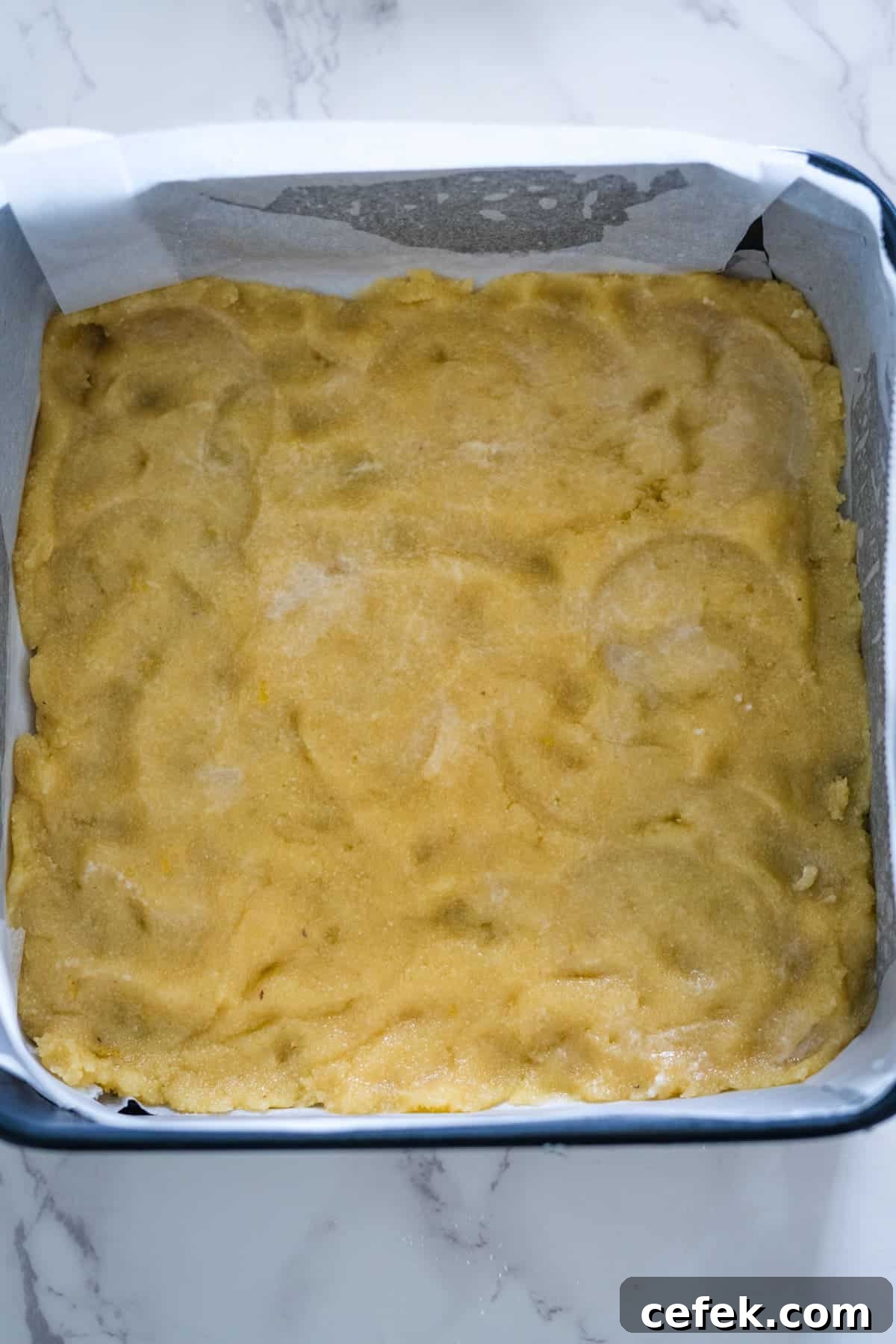 A baking dish with a yellow cake in it.