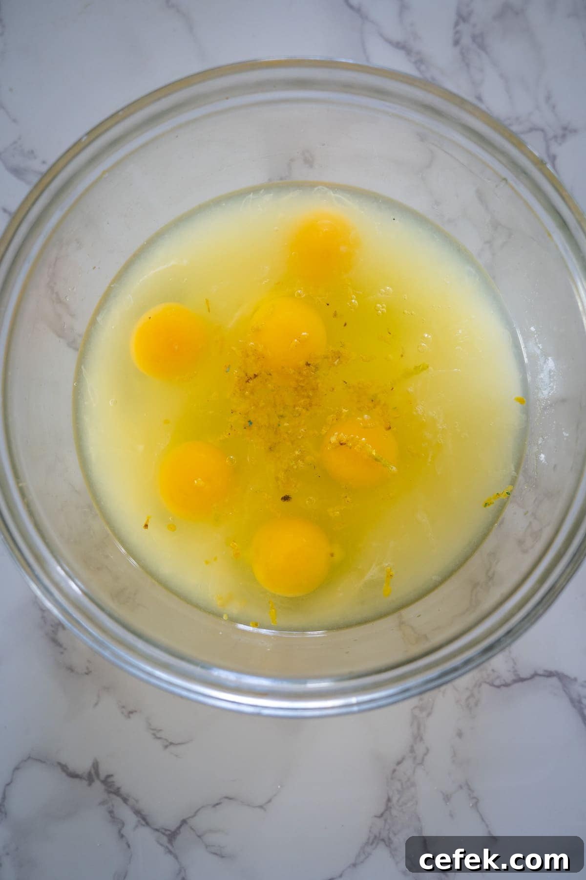 Eggs in a bowl on a marble countertop.