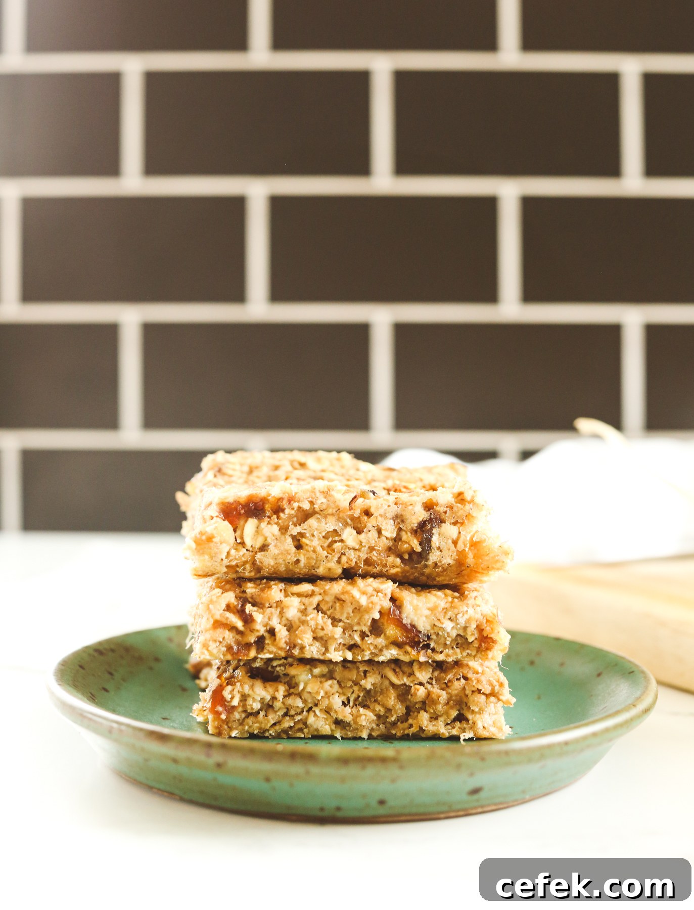 stack of 3 banana oatmeal bars on a green plate with a black background