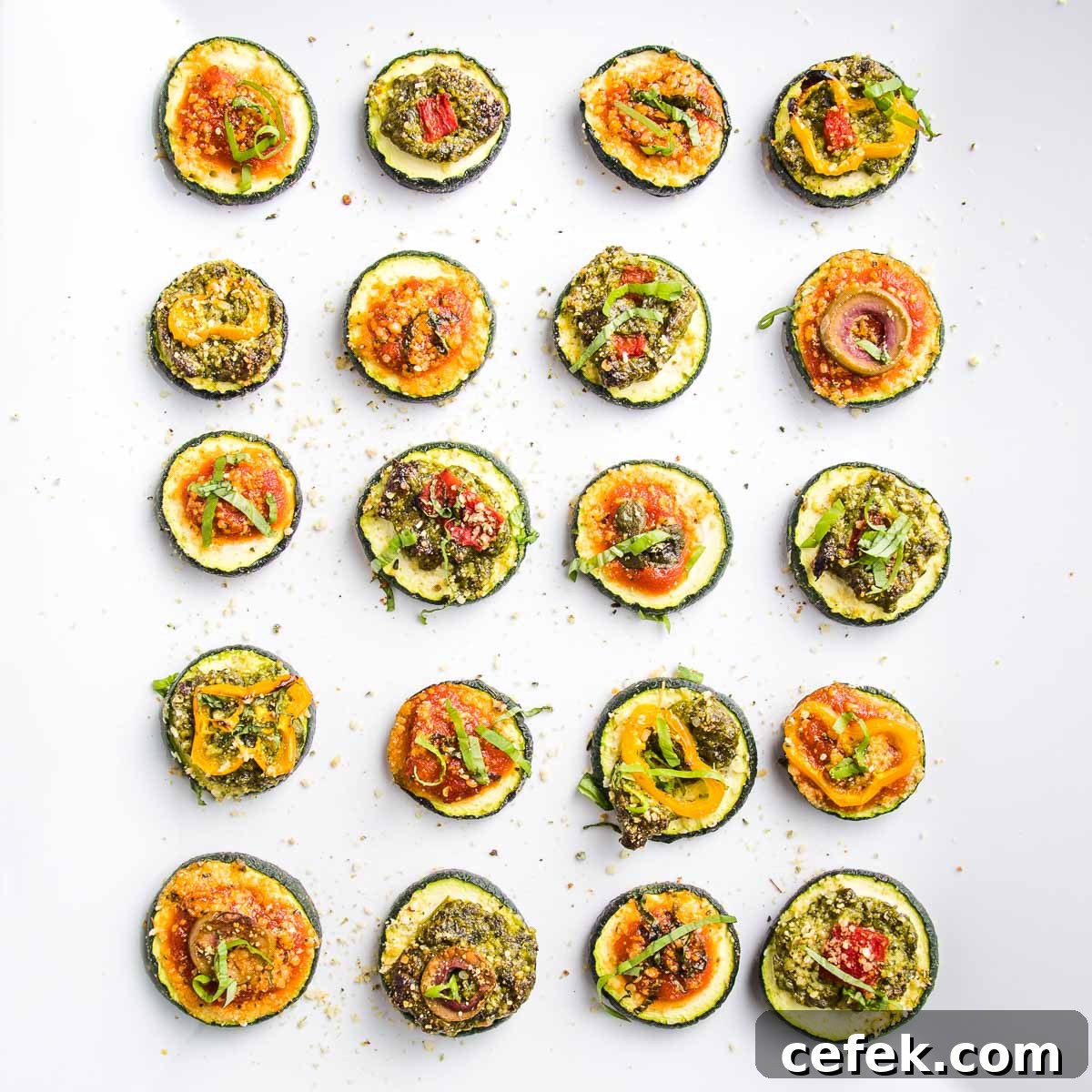 Zucchini rounds baked with pizza toppings, served on a platter.