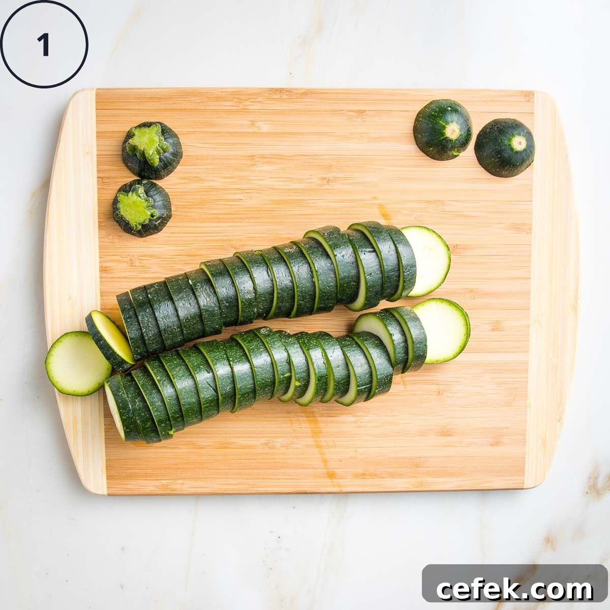 2 Zucchinis sliced into ¼" rounds on a wooden board.