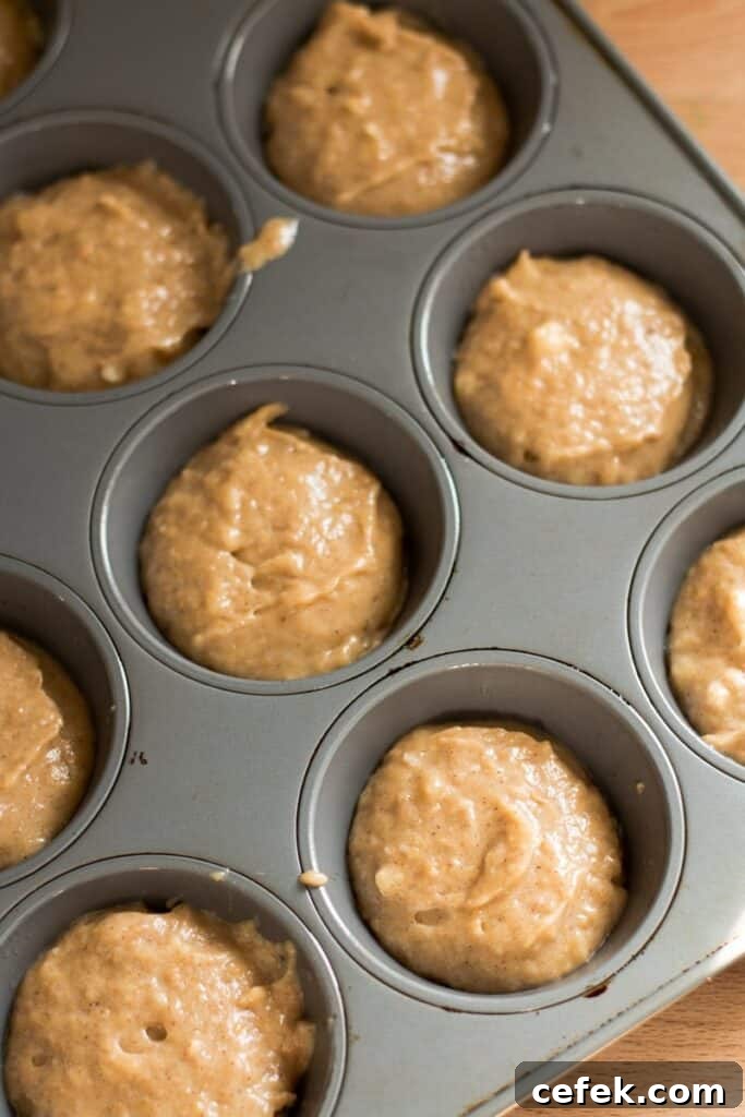 Muffin batter in a muffin tin.