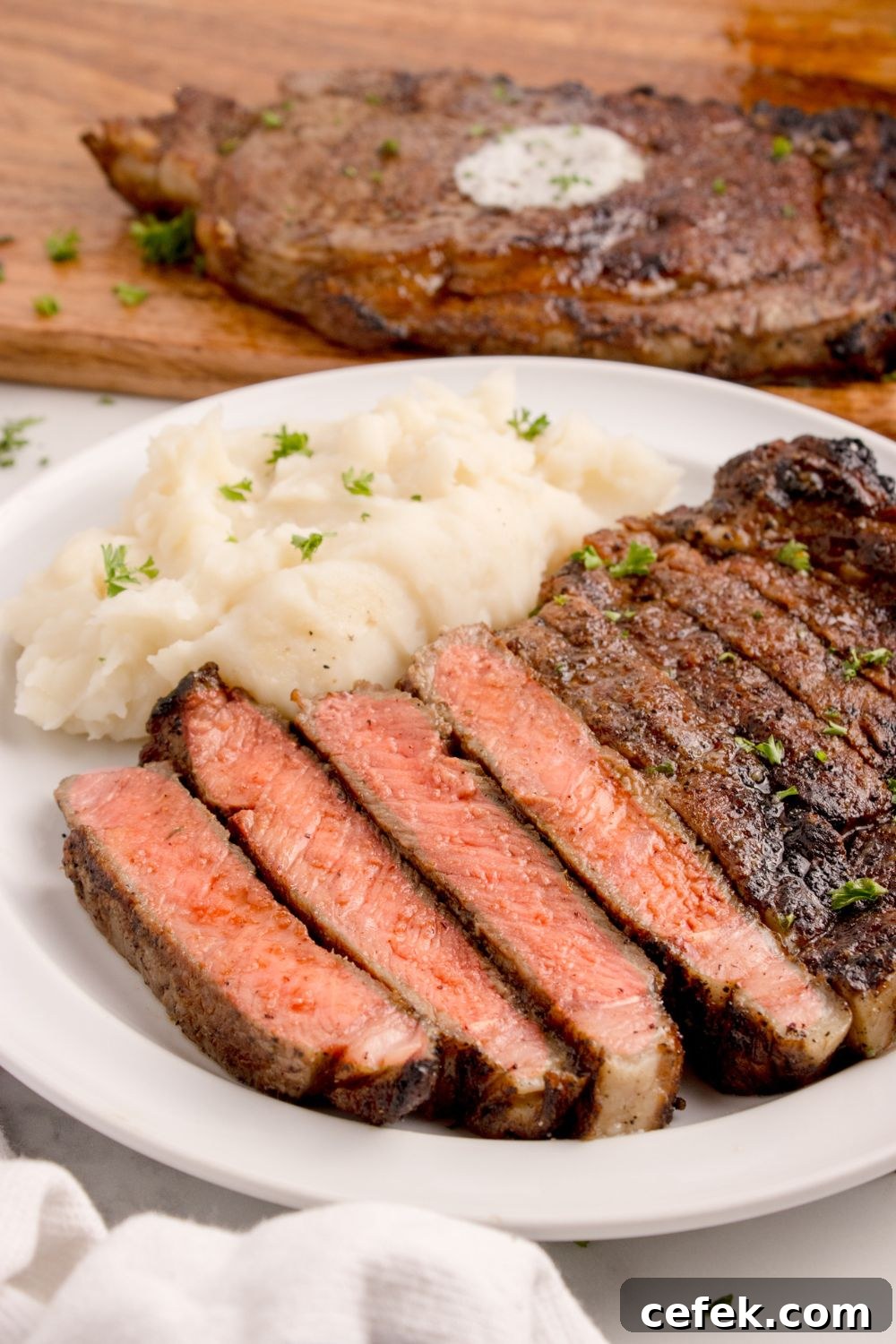 plate with mashed potatoes and sliced Grilled Ribeye Steak on plate 
