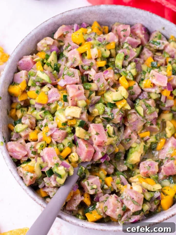 gray spoon scooping up fresh ahi tuna ceviche