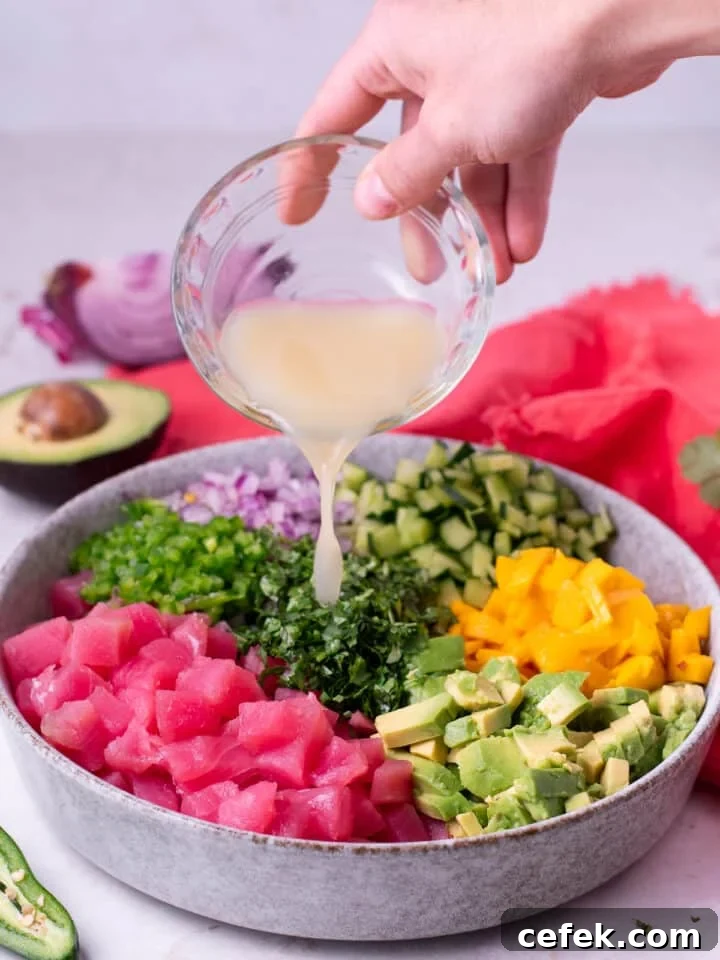 hand pouring a small bowl of lime juice into the ceviche