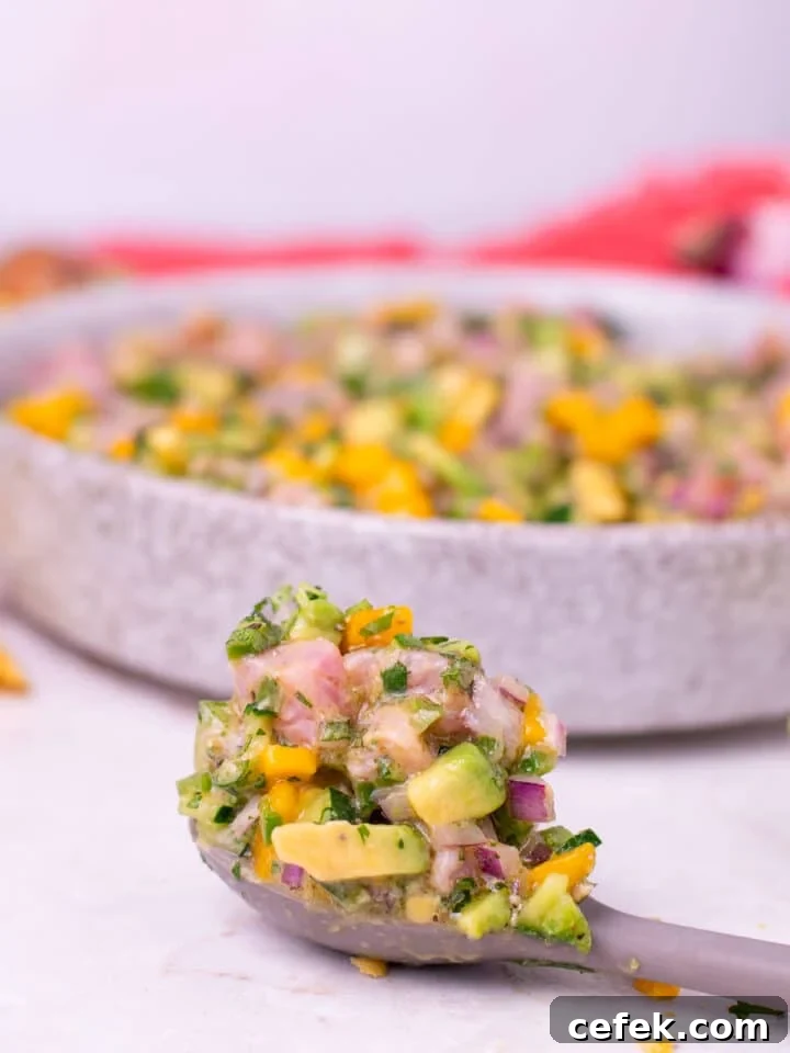 gray spoon with a large scoop of tuna ceviche on it