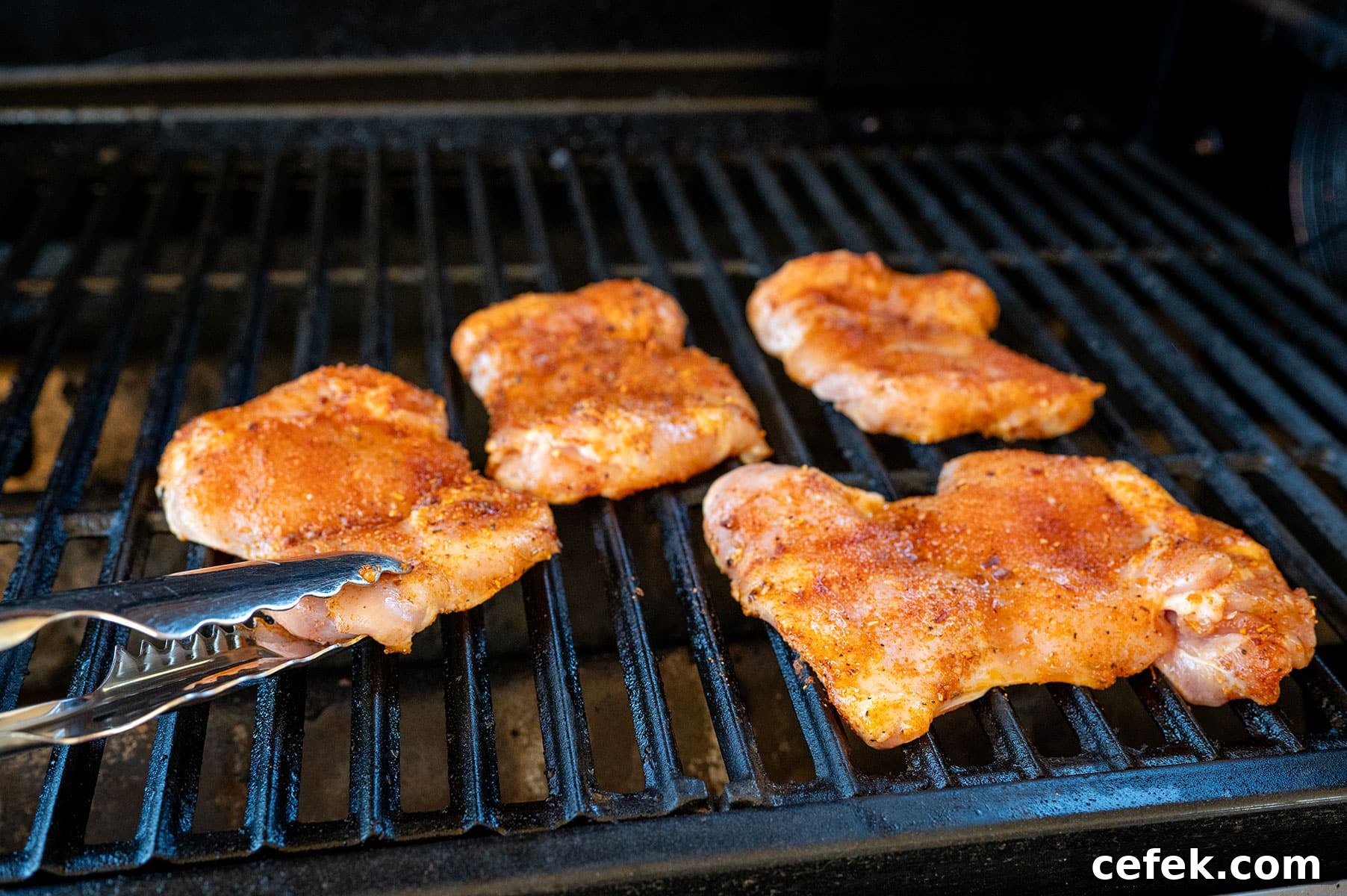 Raw chicken thighs on grill.