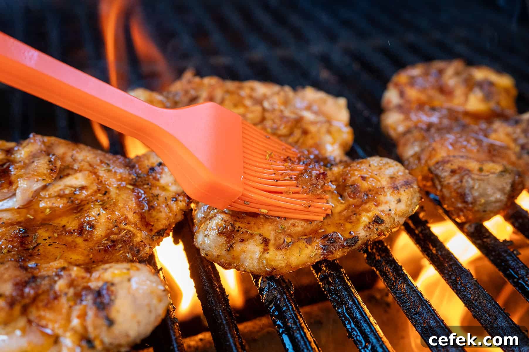 Basting chicken thighs on grill.