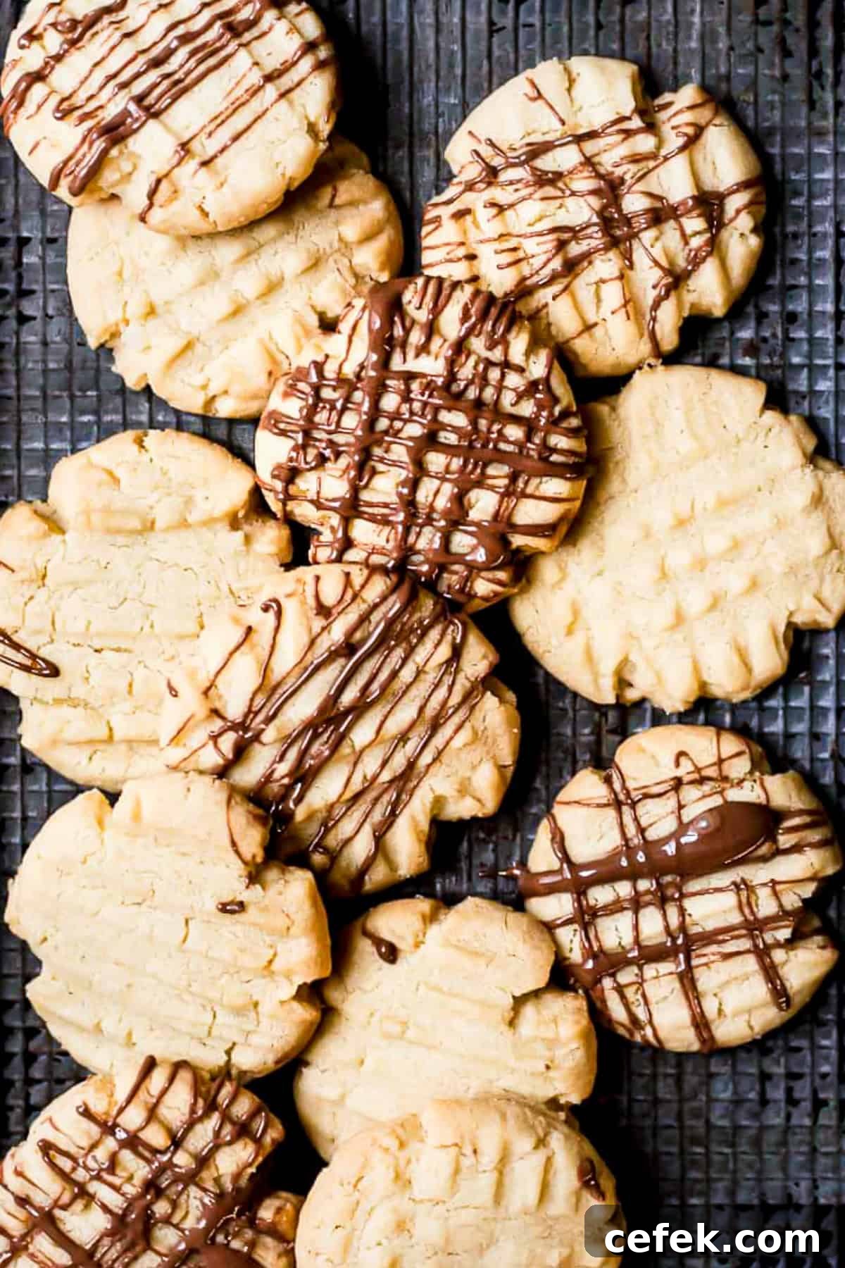Mary Berry fork biscuits drizzled with chocolate on a baking tray.